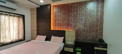 a bedroom with a bed and a large wall at HOTEL AL AMANA TOWER in Kondotti