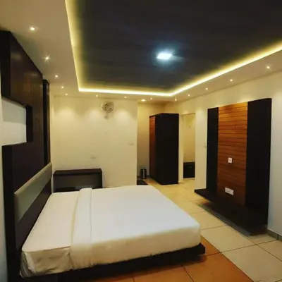 a bedroom with a large white bed in a room at HOTEL AL AMANA TOWER in Kondotti
