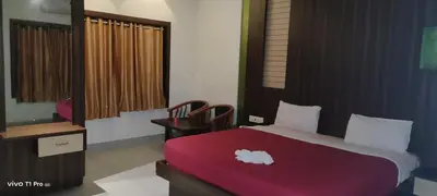 a bedroom with a large bed with a red blanket at HOTEL AL AMANA TOWER in Kondotti