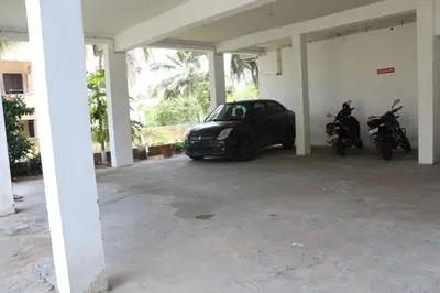 a garage with two motorcycles and a car parked in it at Shree SaiRenu near maruthamalai and bharathiyar univ and on the way to Adiyogi Isha Yoga centre in Marudhamalai