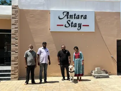 a group of people standing in front of a shop with a dog at ANTARA STAY in Coimbatore