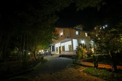 a house at night with its lights on at B'camp Resorts & Homestays in Wayanad