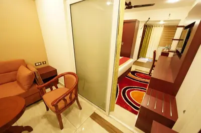 a living room with a couch and a mirror at Hotel Newline Orchid in Guruvāyūr