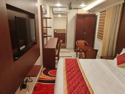a hotel room with a bed and a television at Hotel Newline Orchid in Guruvāyūr