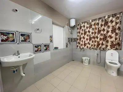 a bathroom with a sink and a toilet and a shower curtain at Heath Cote in Ooty