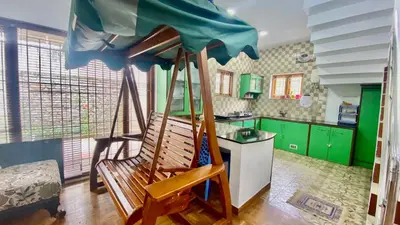 a wooden swing in a kitchen with green cabinets at La Flora kodaikanal in Kodaikānāl