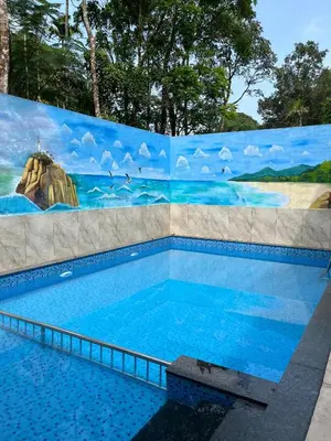 a swimming pool with a painting on a wall at Safari Hills in Vayittiri
