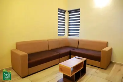 a living room with a brown couch and a table at Safari Hills in Vayittiri
