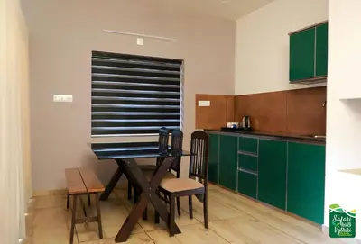 a kitchen with a table and some green cabinets at Safari Hills in Vayittiri