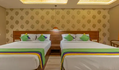 two beds in a hotel room with two beds sidx sidx sidx at Treebo Windsor Heights, 8 Mins To Ketti Valley View Point in Ooty
