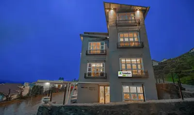a tall building with windows and a sign on it at Treebo Windsor Heights, 8 Mins To Ketti Valley View Point in Ooty