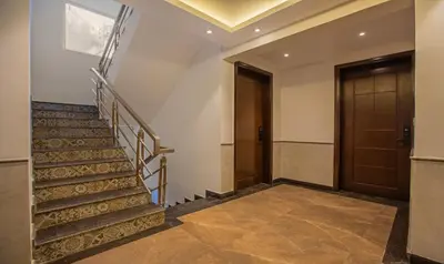 a hallway with stairs and a wooden door at Treebo Windsor Heights, 8 Mins To Ketti Valley View Point in Ooty