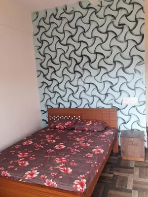 a bedroom with a bed with a patterned wall at Paadi Inn in Kakkabe
