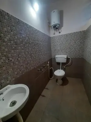 a bathroom with a sink and a toilet at Paadi Inn in Kakkabe