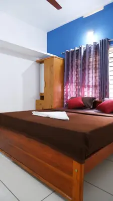 a large wooden bed in a room with a window at WAYANAD OASIS VILLa in Kalpetta