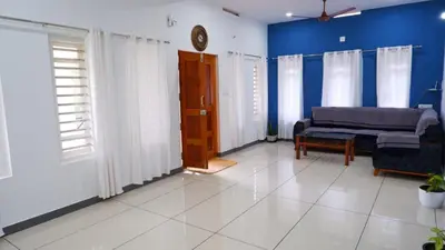 a living room with a couch and blue walls at WAYANAD OASIS VILLa in Kalpetta