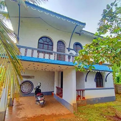 a house with a motorcycle parked in front of it at Kalpetta Peace Villa in Kalpetta