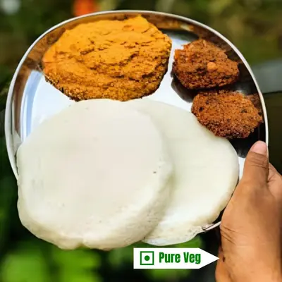 a hand holding a plate of pure veggie food at Mannat Inn (Peace Homestay) in Mysore