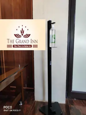 a sign for the grand inn with a bottle on a stand at The Grand Inn Mysore in Mysore