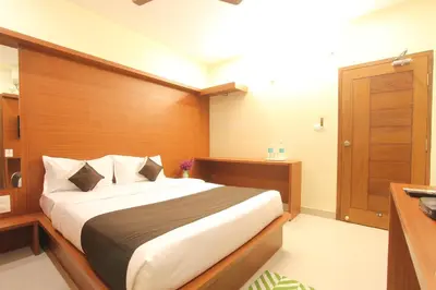 a bedroom with a large bed and a wooden wall at The Grand Inn Mysore in Mysore