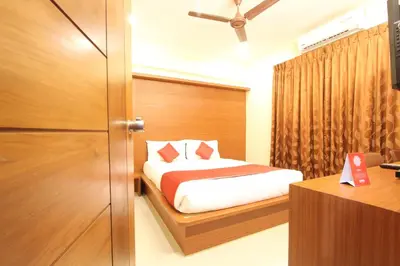 a bedroom with a bed and a door and a desk at The Grand Inn Mysore in Mysore