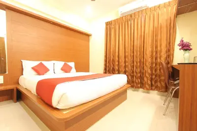 a bedroom with a large bed with a wooden headboard at The Grand Inn Mysore in Mysore