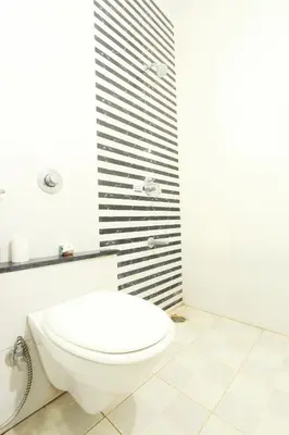 a bathroom with a white toilet and a shower at The Grand Inn Mysore in Mysore