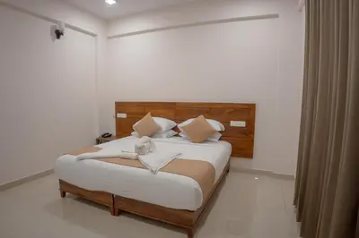 a bedroom with a large bed with a wooden headboard at Daffodils Luxury Airport Suites in Cochin
