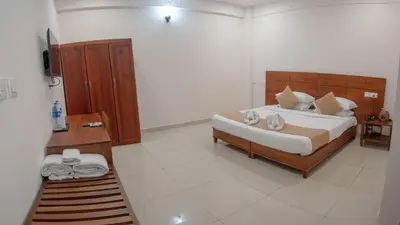 a bedroom with a large bed in a room at Daffodils Luxury Airport Suites in Cochin