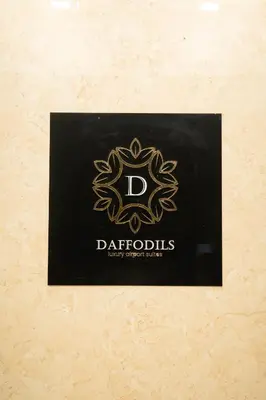a black plaque with a daffodils logo on it at Daffodils Luxury Airport Suites in Cochin
