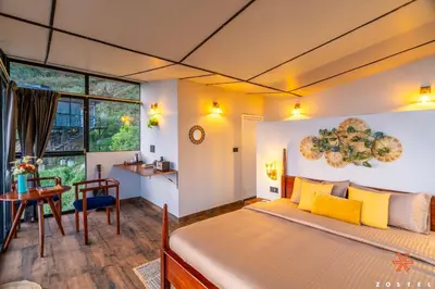 a bedroom with a large bed with yellow pillows at Zostel Plus Poombarai, Kodaikanal in Kodaikānāl