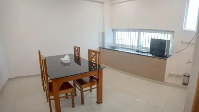 a room with a table and chairs and a television at Daffodils Luxury Airport Suites in Angamali