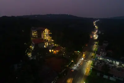 a city at night with lights on a street at Woodbine Foliage in Malappuram