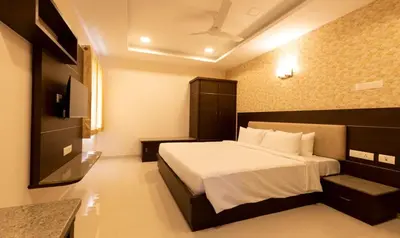 a hotel room with a bed and a television at The Bee Hives , Nectar Nest in Coimbatore