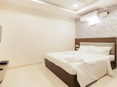 a bedroom with a large bed with white sheets at The Bee Hives , Nectar Nest in Coimbatore