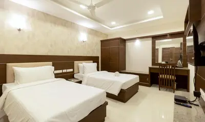 a hotel room with two beds and a mirror at The Bee Hives , Nectar Nest in Coimbatore