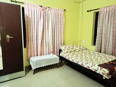 a small bedroom with a bed and a window at Pebbles in Kozhikode