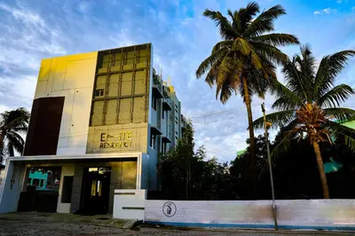 a building with palm trees in front of it at ELITE RESIDENCY in Palani