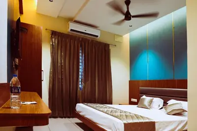 a bedroom with a bed and a table and a ceiling fan at ELITE RESIDENCY in Palani