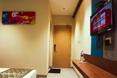 a room with a door and a television on the wall at ELITE RESIDENCY in Palani
