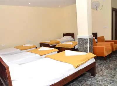 a row of beds in a room with a room with at Sanjose Residency in Virajpet