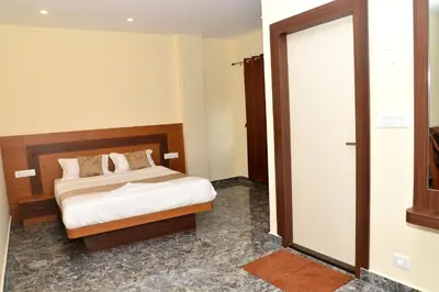 a bedroom with a bed and a sliding door at Sanjose Residency in Virajpet