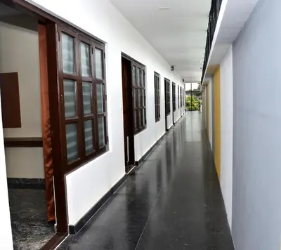 an empty corridor of a building with doors and windows at Sanjose Residency in Virajpet