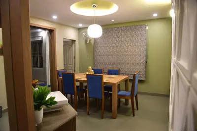 a dining room with a table and blue chairs at Ivory sea castle in Kozhikode