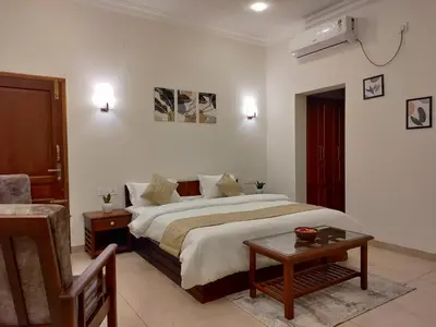 a bedroom with a large bed and a table at The Cana's Coorg in Ammatti