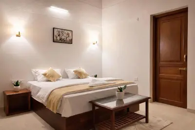 a bedroom with a large bed and a table at The Cana's Coorg in Ammatti