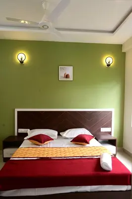 a green bedroom with a large bed with red pillows at The Green Room Residency in Padinjarathara