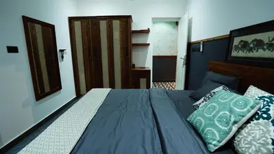 a bedroom with a bed with blue sheets and pillows at Lofterra in Kozhikode