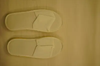 two white shoes are sitting on a table at Bamboo Grove in Mānantoddy