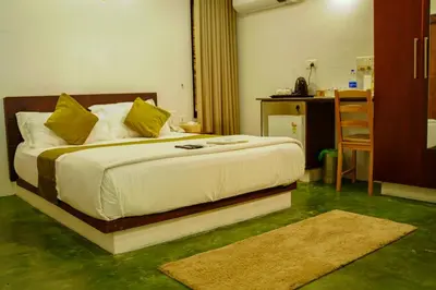 a bedroom with a large bed with yellow pillows at Bamboo Grove in Mānantoddy